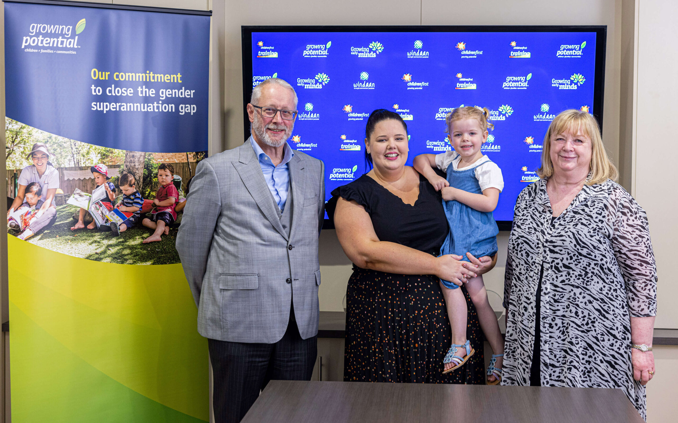 Group photo of Growing Potential's CEO Otto Henfling, Chair of the Board Carol Vella, and Employee Relations Coordinator Ashleigh Bender with her 3 year old daughter Lola, taken in a boardroom